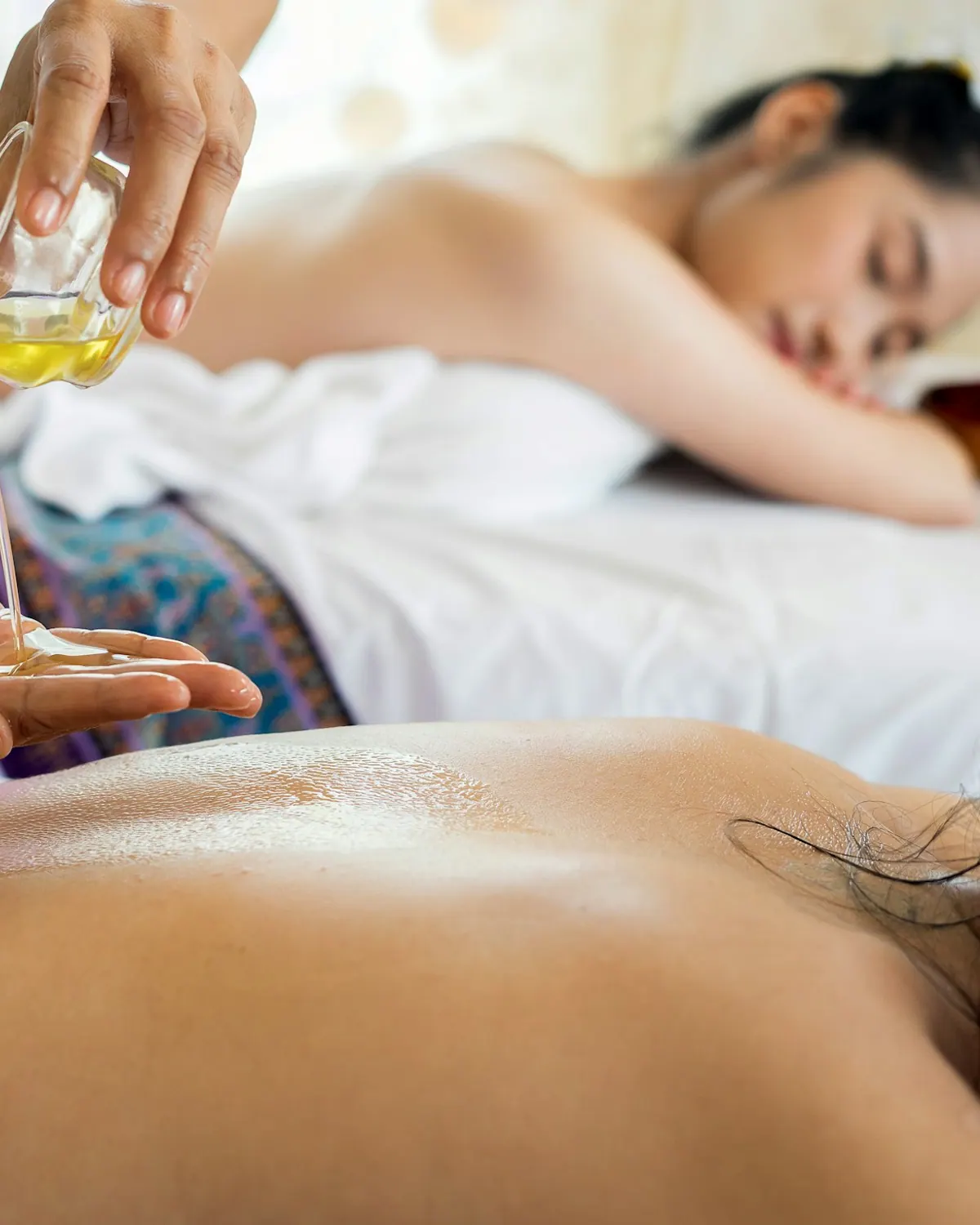 Spa attendant preparing massage oil for a body treatment